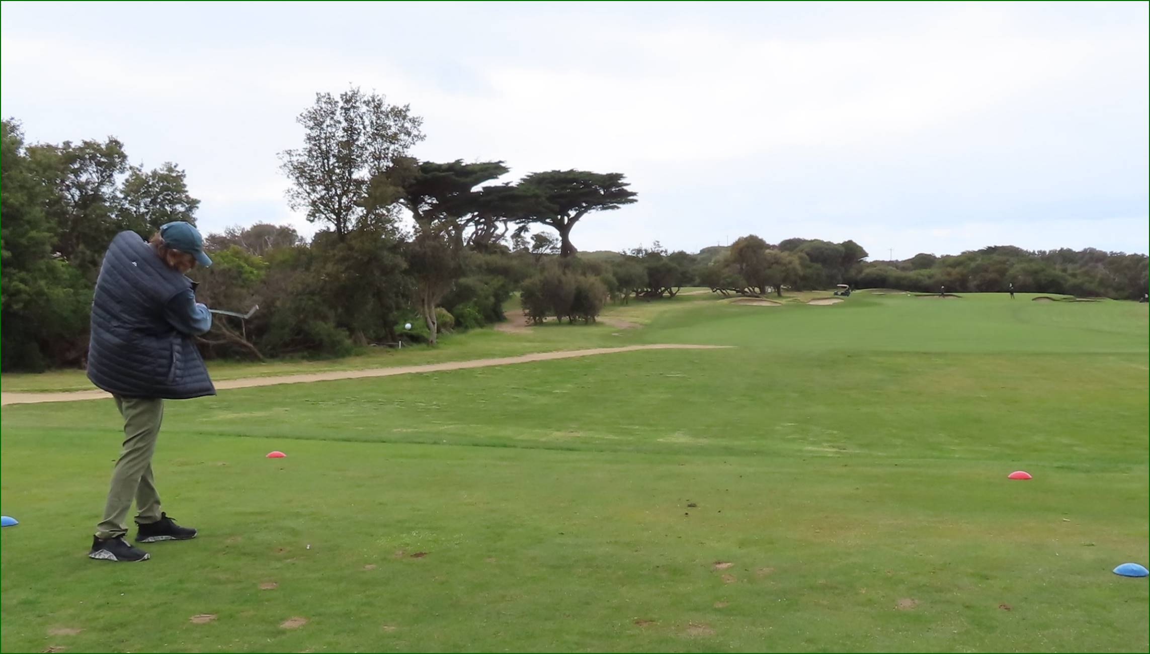 A golf course with trees and a path

Description automatically generated
