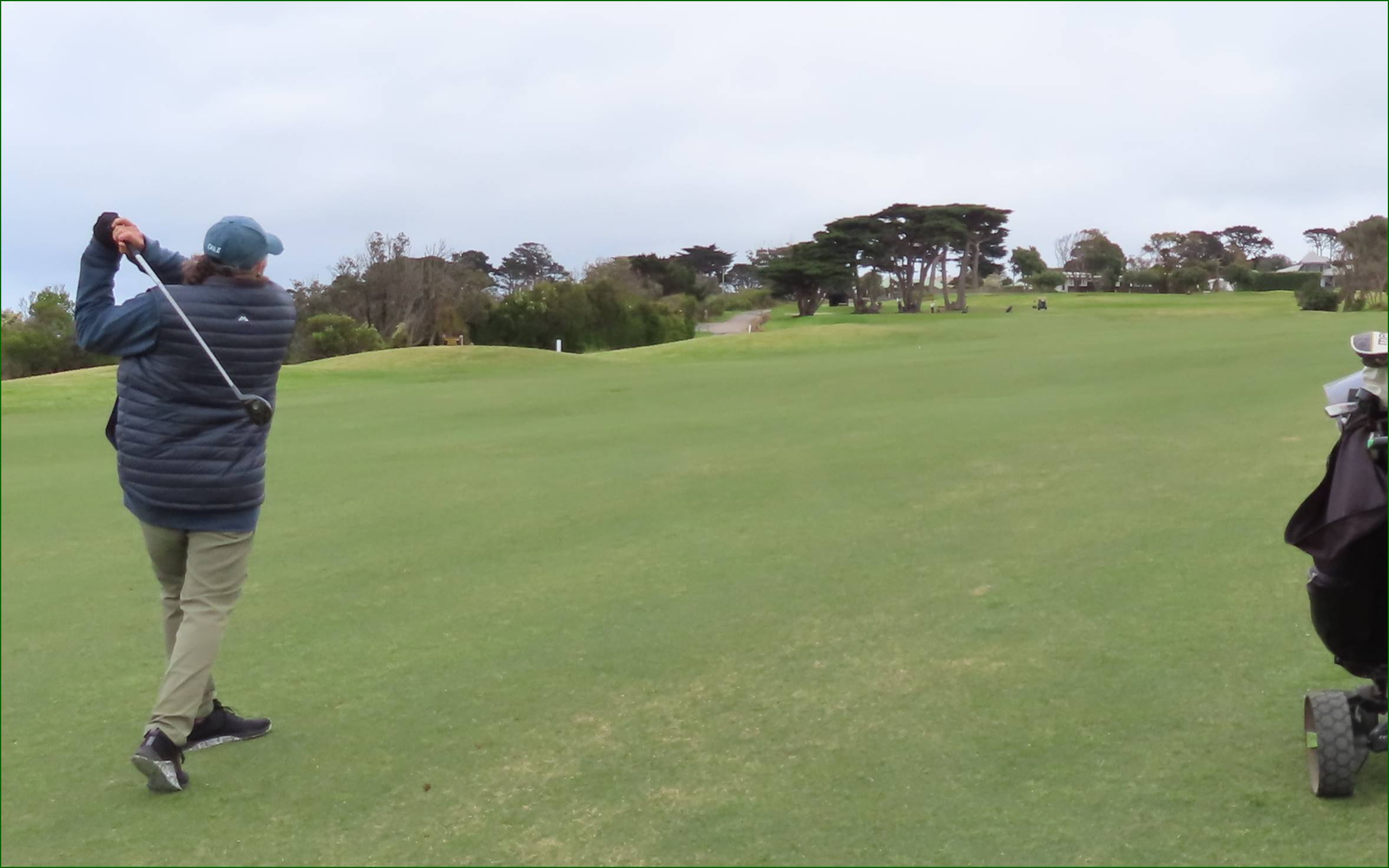 A person standing on a golf course

Description automatically generated