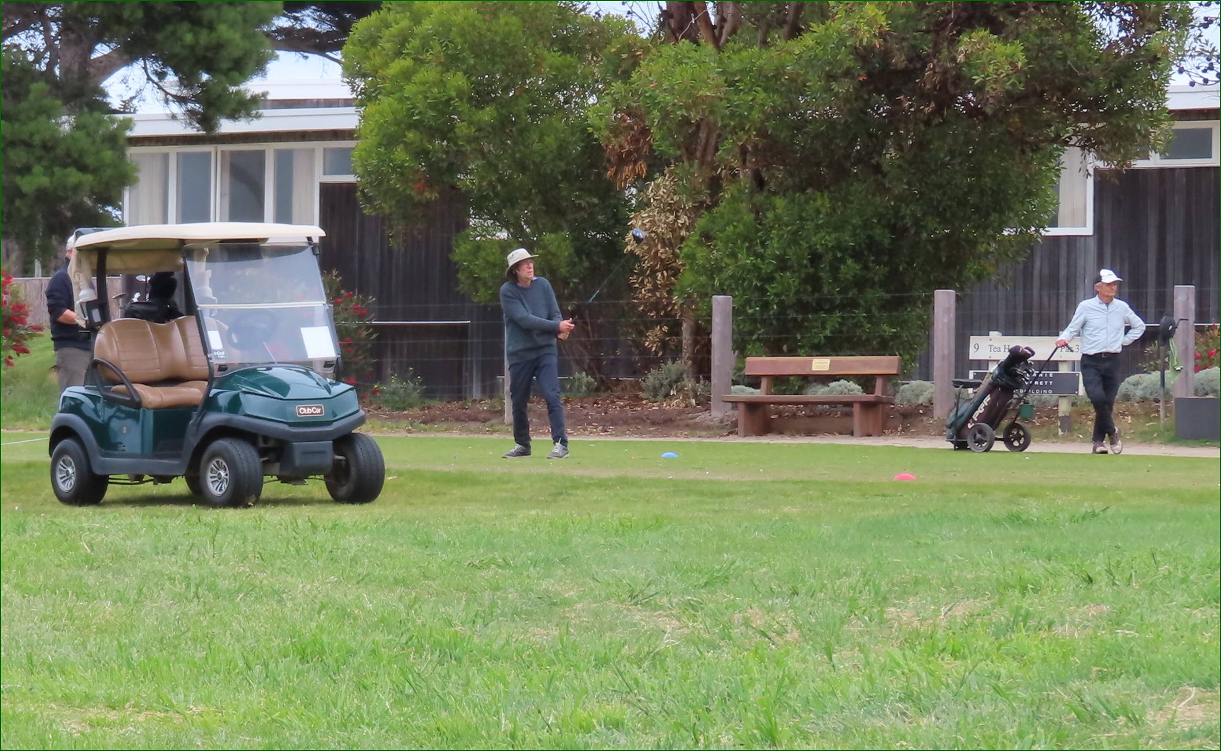 A person standing on a golf cart

Description automatically generated