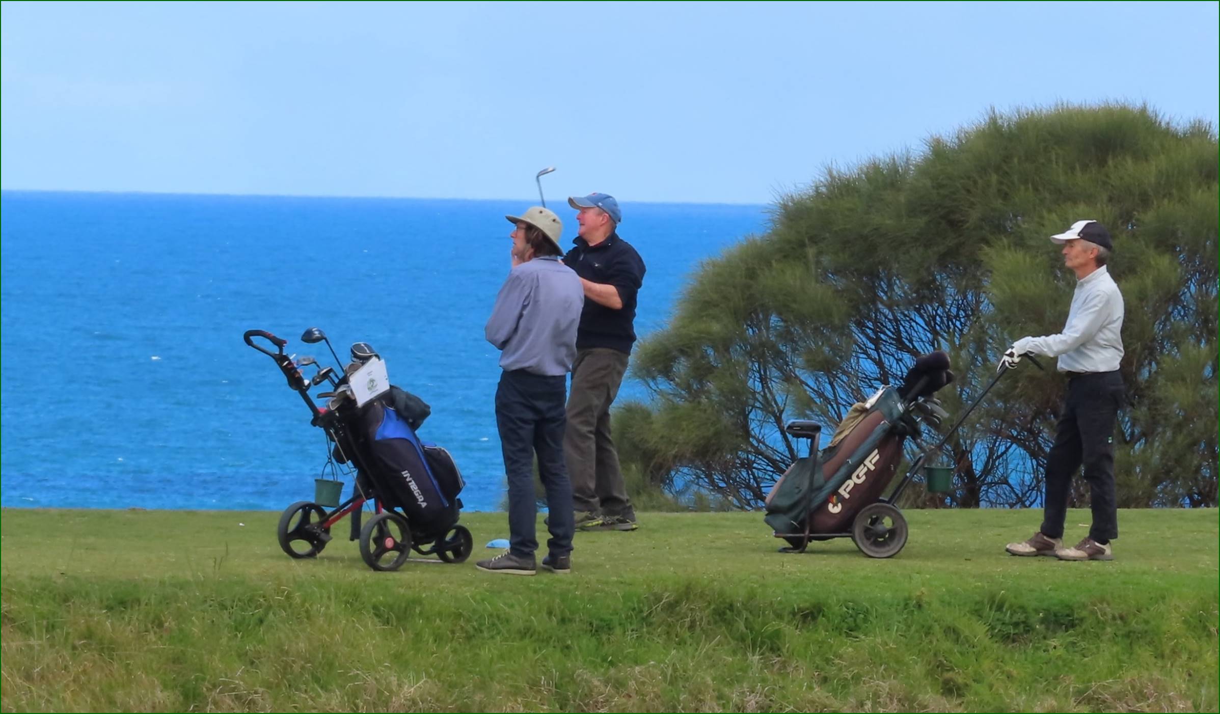 A group of men standing on a golf course

Description automatically generated
