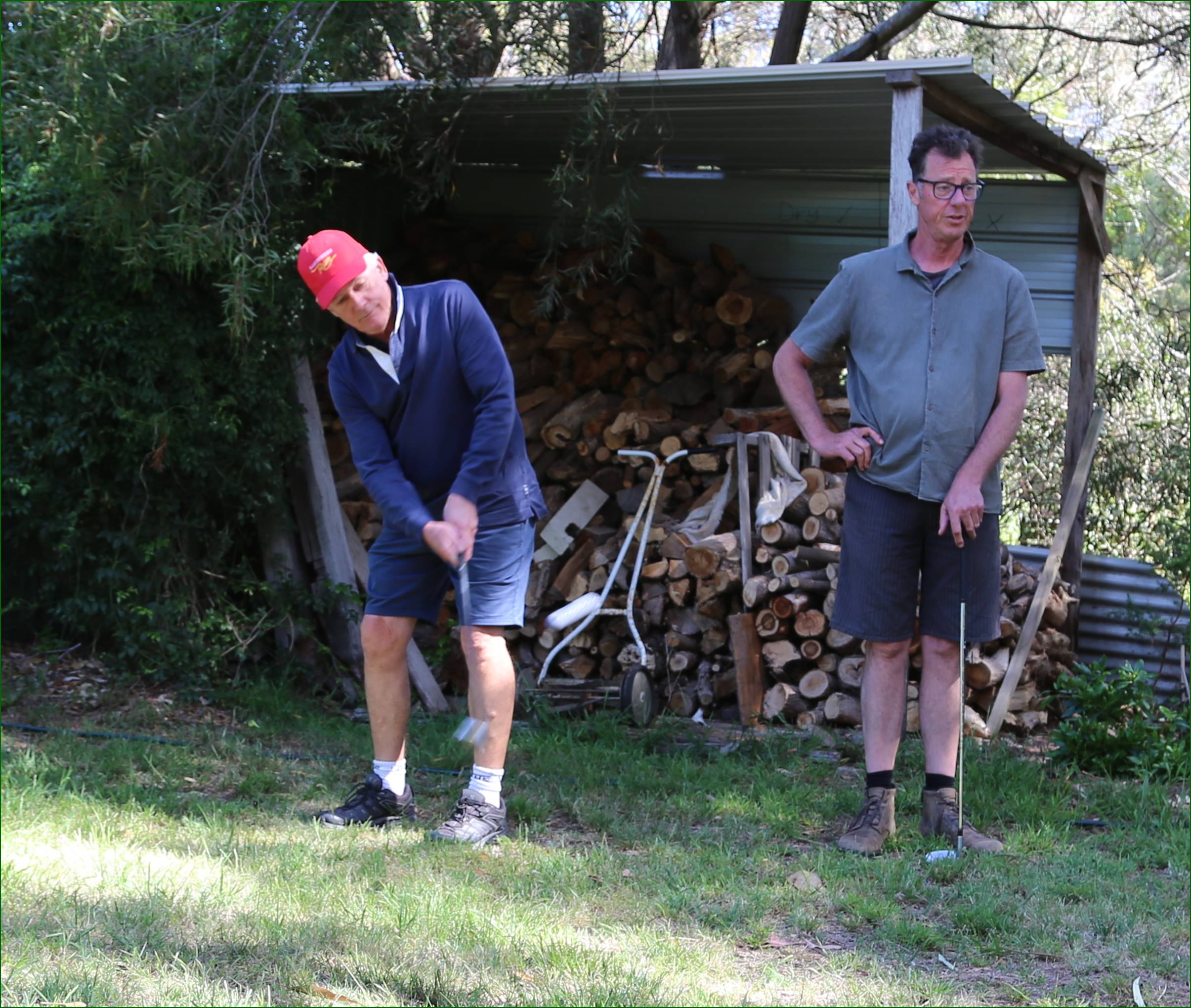 Two men playing golf in the yard

Description automatically generated