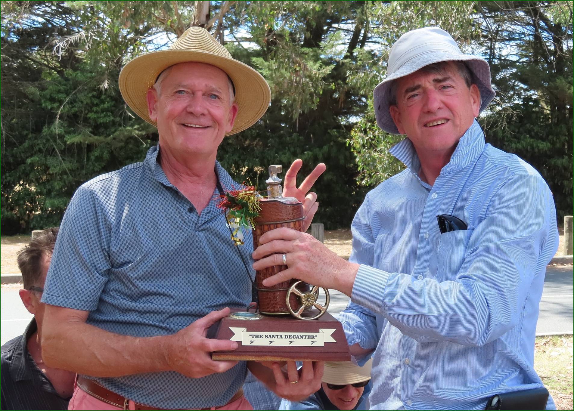 A couple of men holding a trophy

Description automatically generated