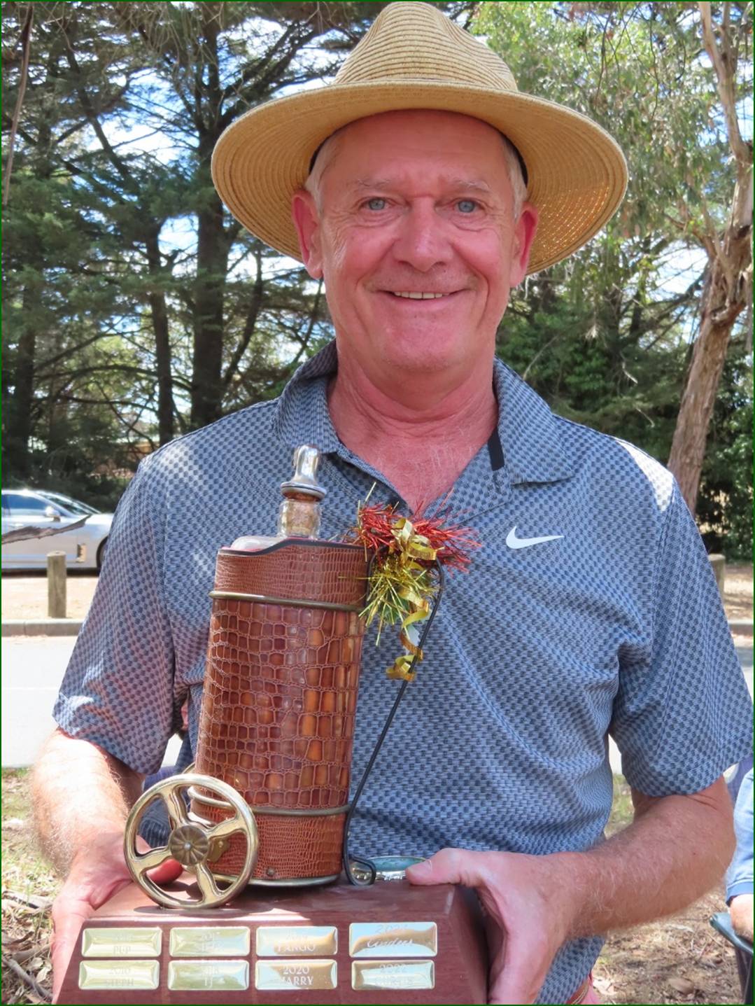 A person wearing a straw hat holding a bottle

Description automatically generated