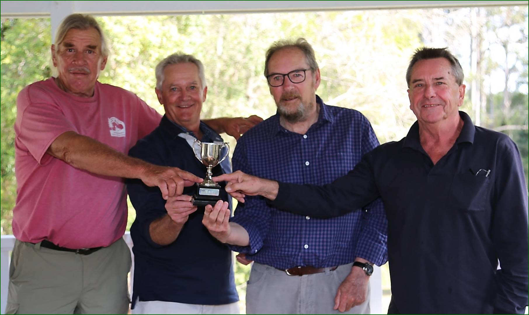 A group of men holding a trophy

Description automatically generated