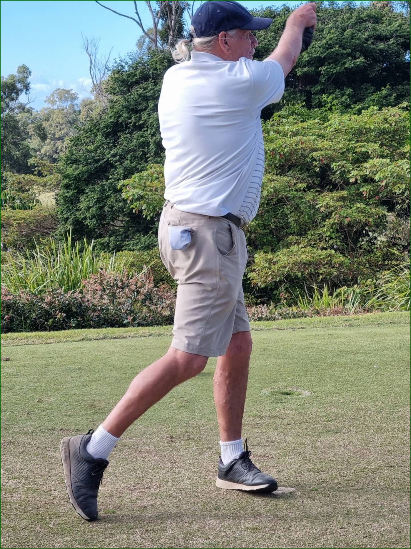 A person swinging a golf club

Description automatically generated