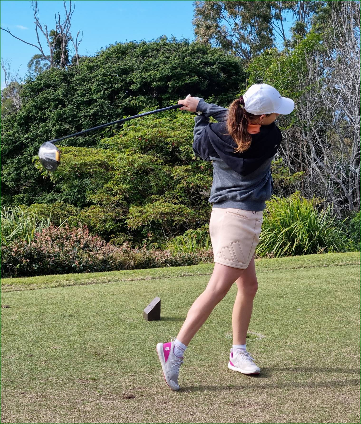 A person swinging a golf club

Description automatically generated
