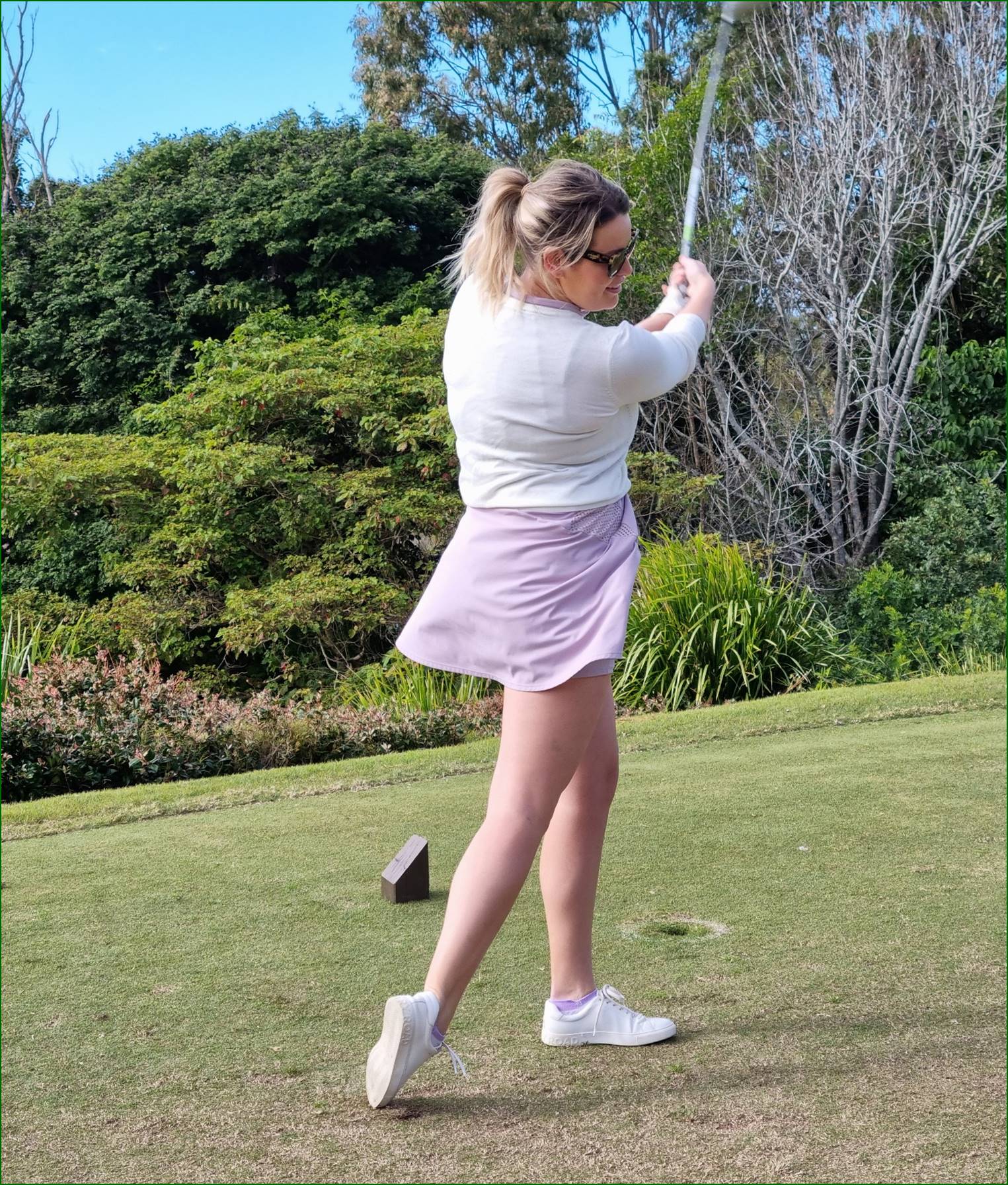 A person swinging a golf club

Description automatically generated