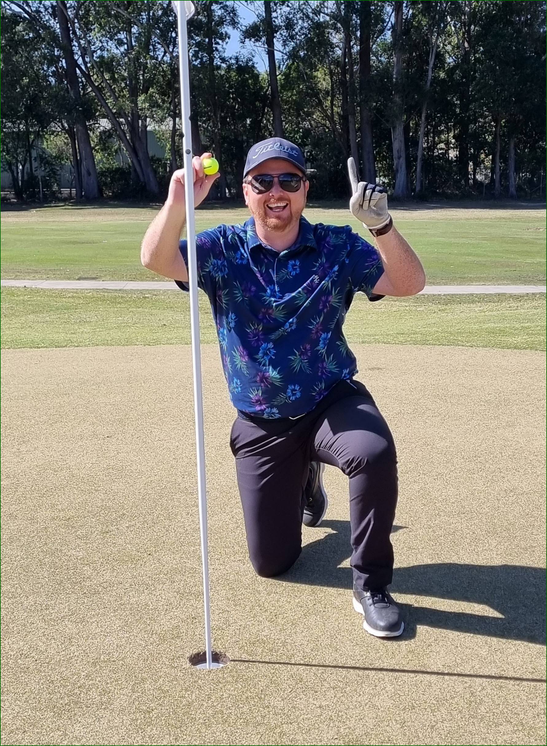 A person holding a golf ball and a golf club

Description automatically generated