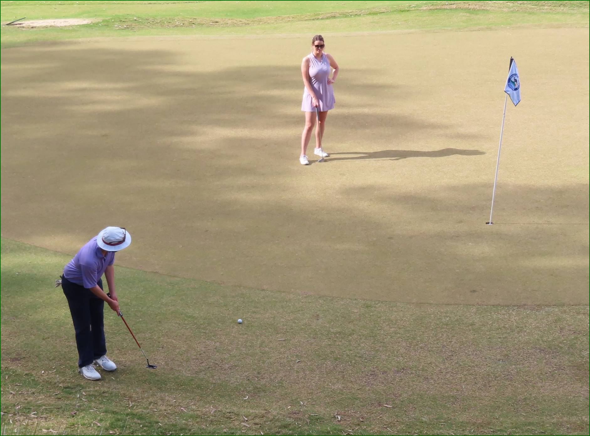 A person and person playing golf

Description automatically generated