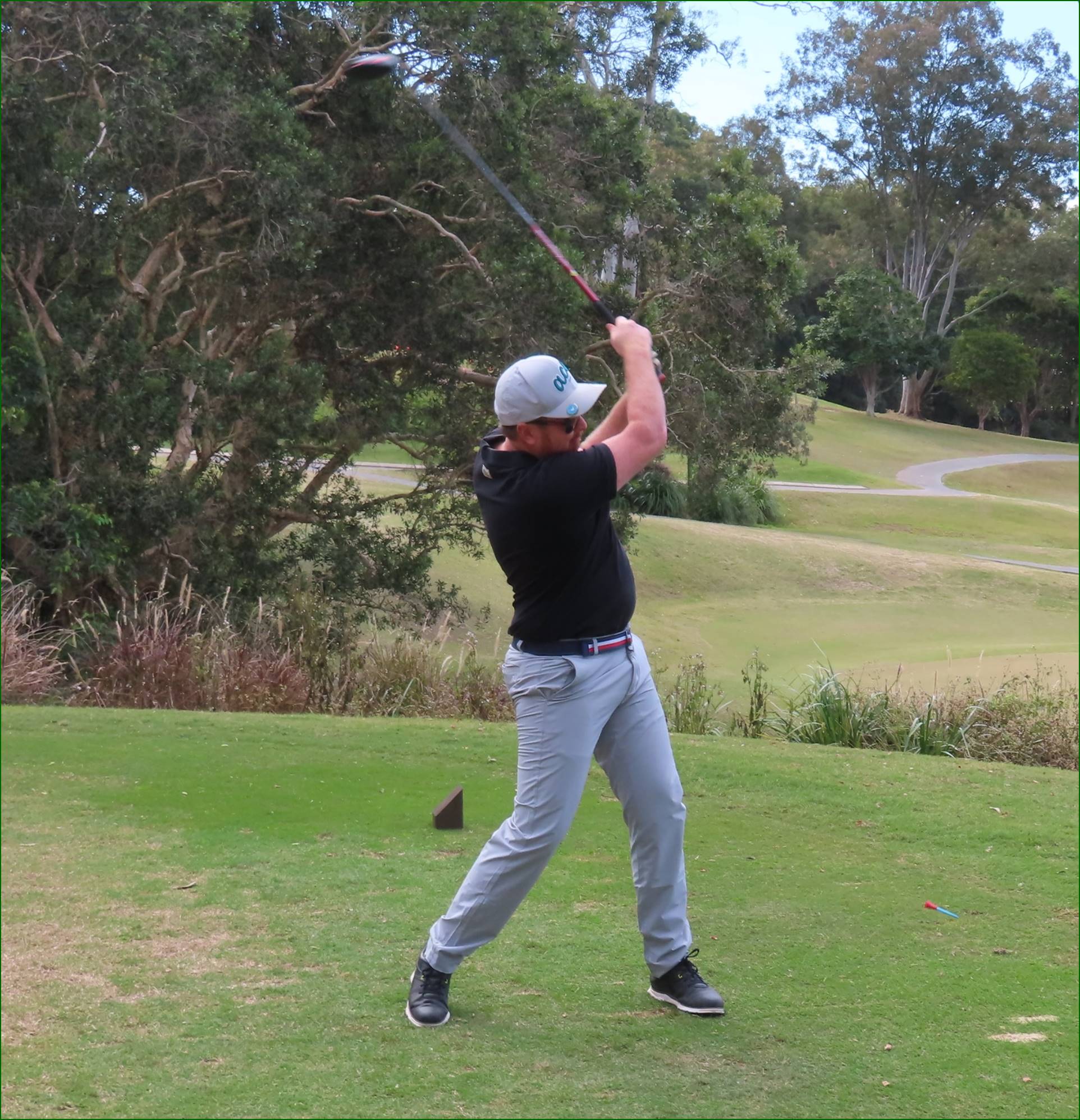 A person swinging a golf club

Description automatically generated