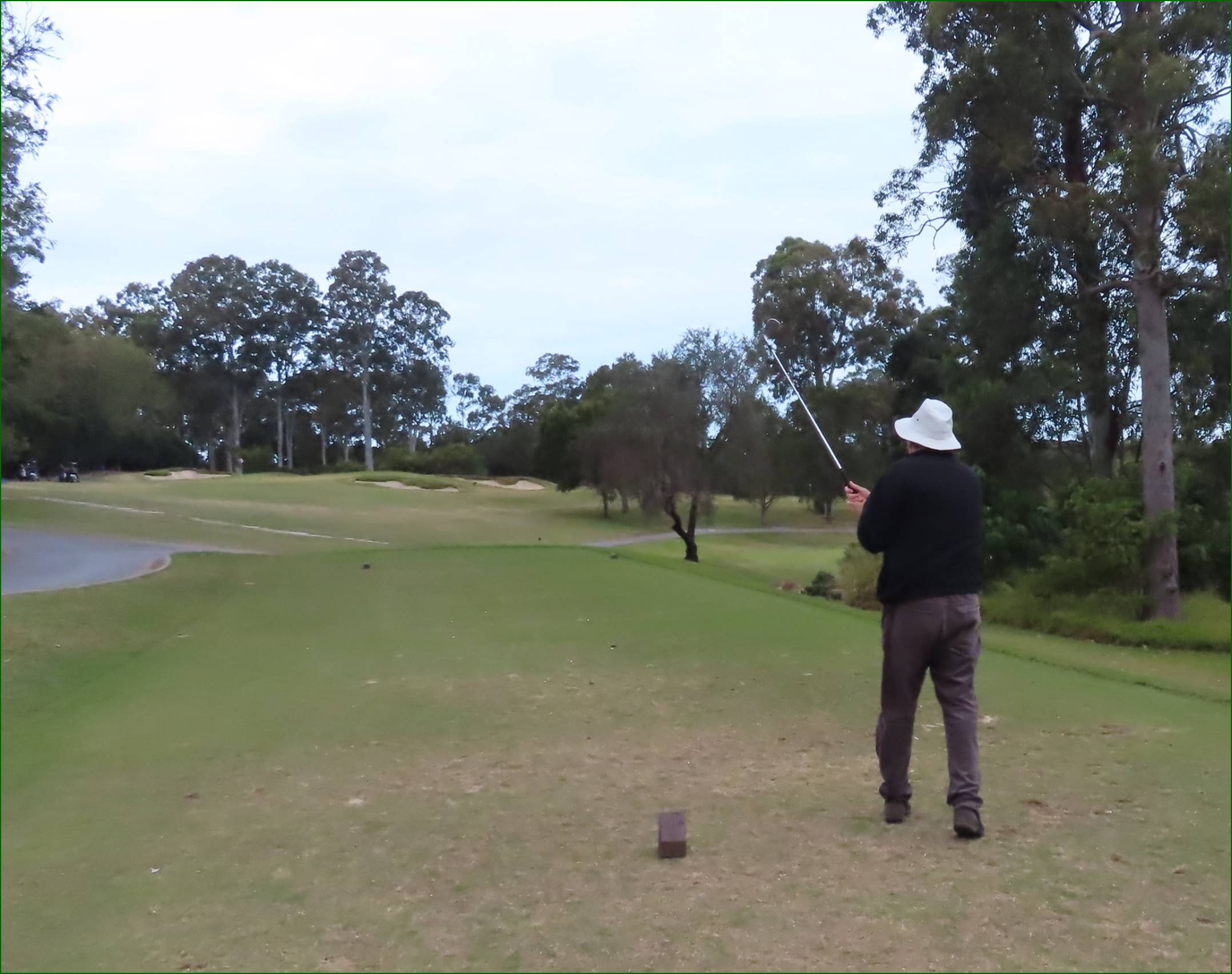 A person standing on a golf course

Description automatically generated
