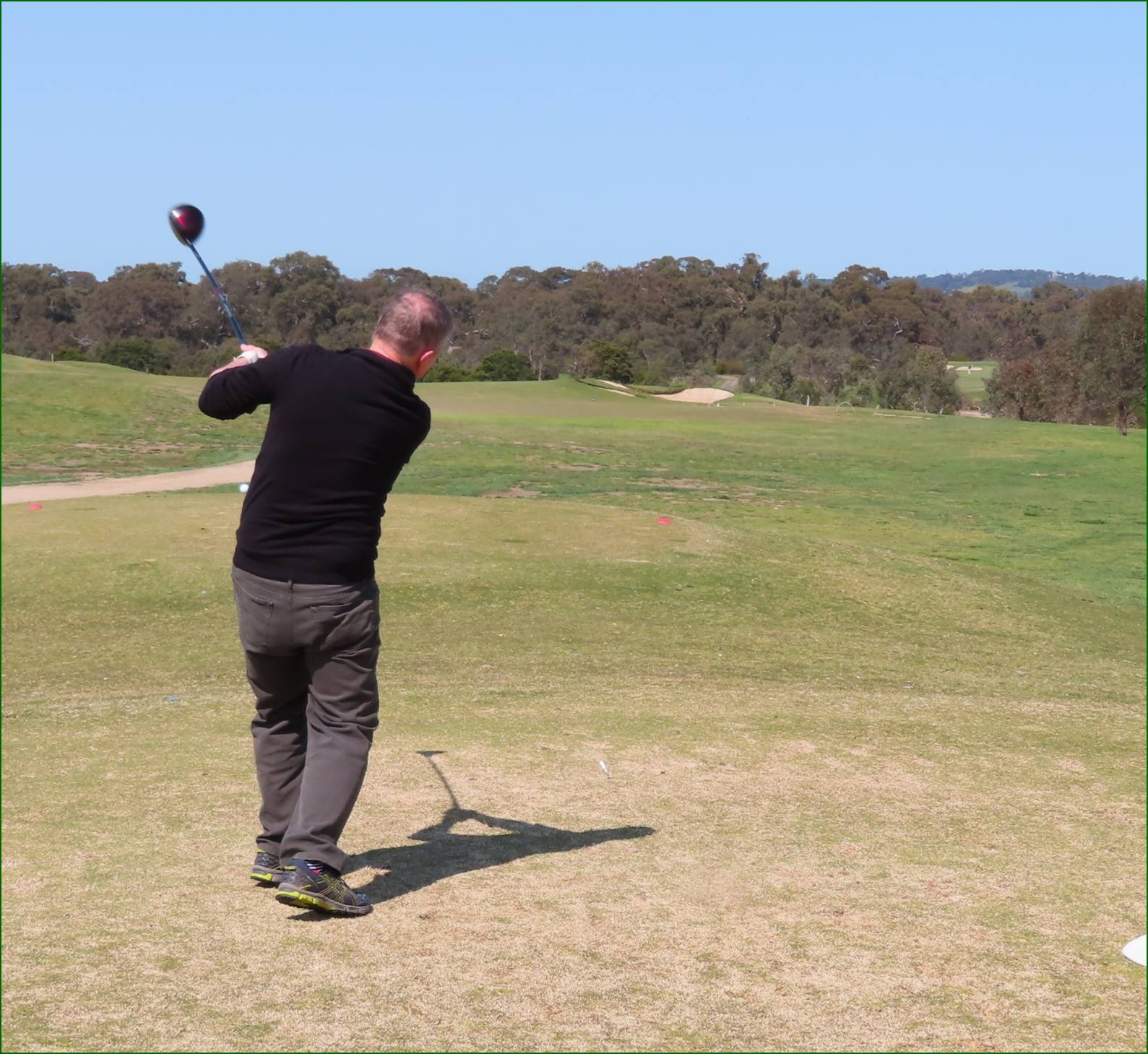 A person swinging a golf club

Description automatically generated