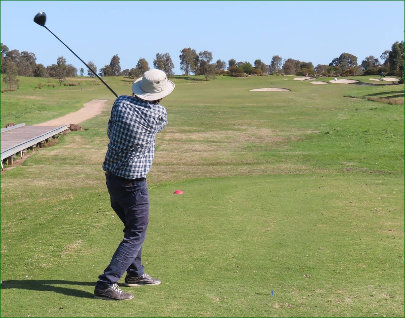 A person swinging a golf club

Description automatically generated