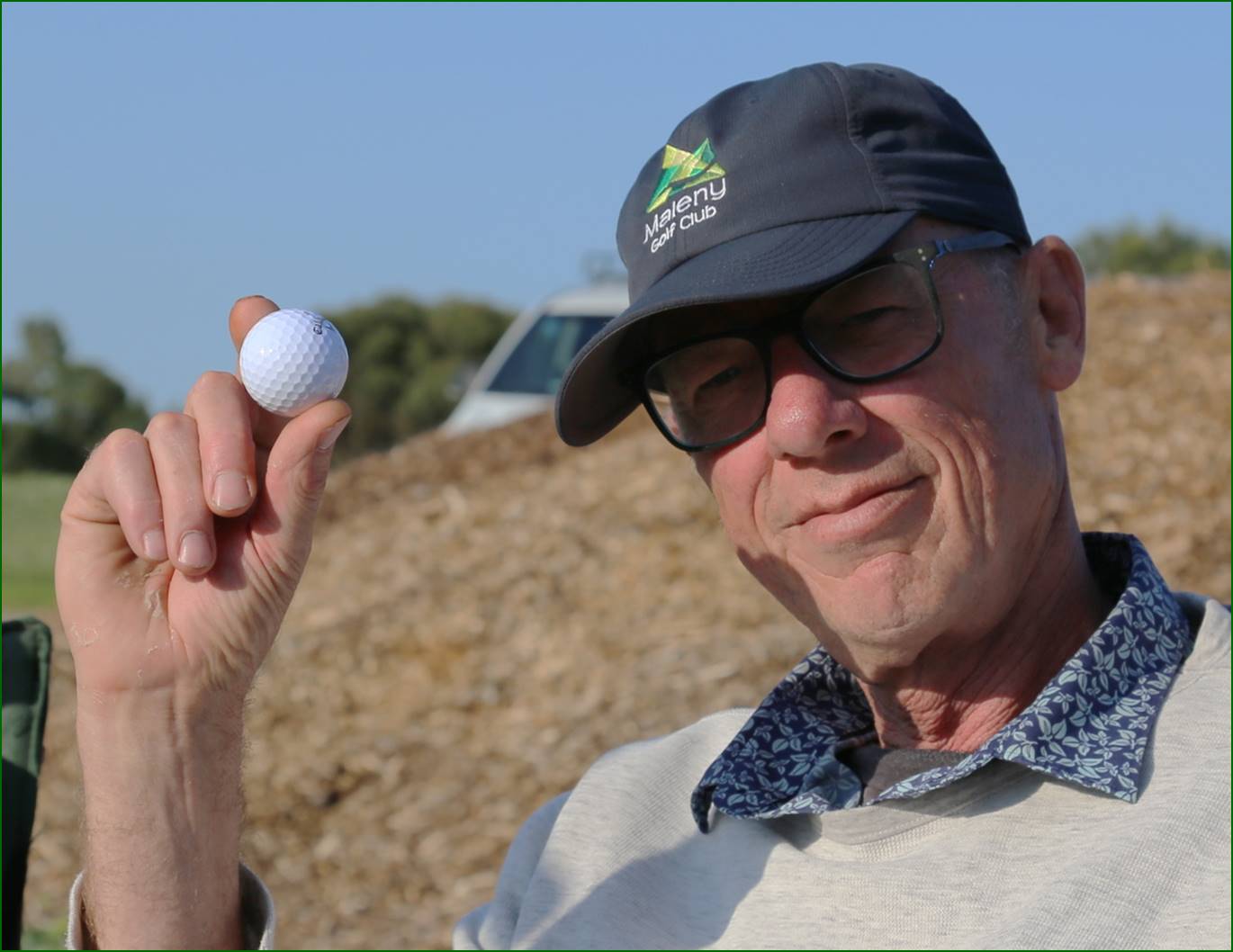 A person holding a golf ball

Description automatically generated