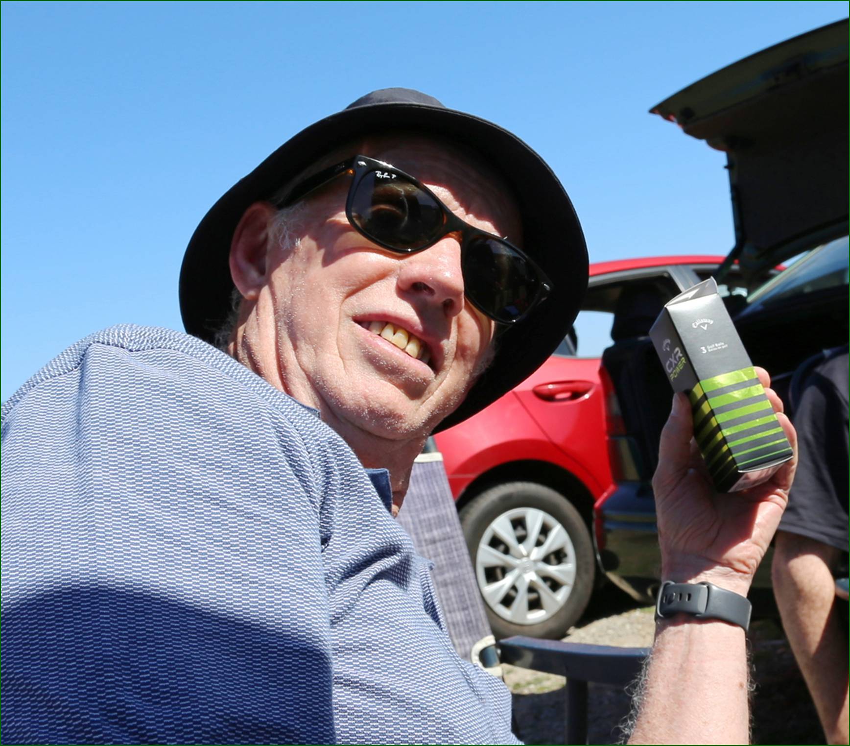 A person wearing sunglasses and a hat holding a box

AI-generated content may be incorrect.