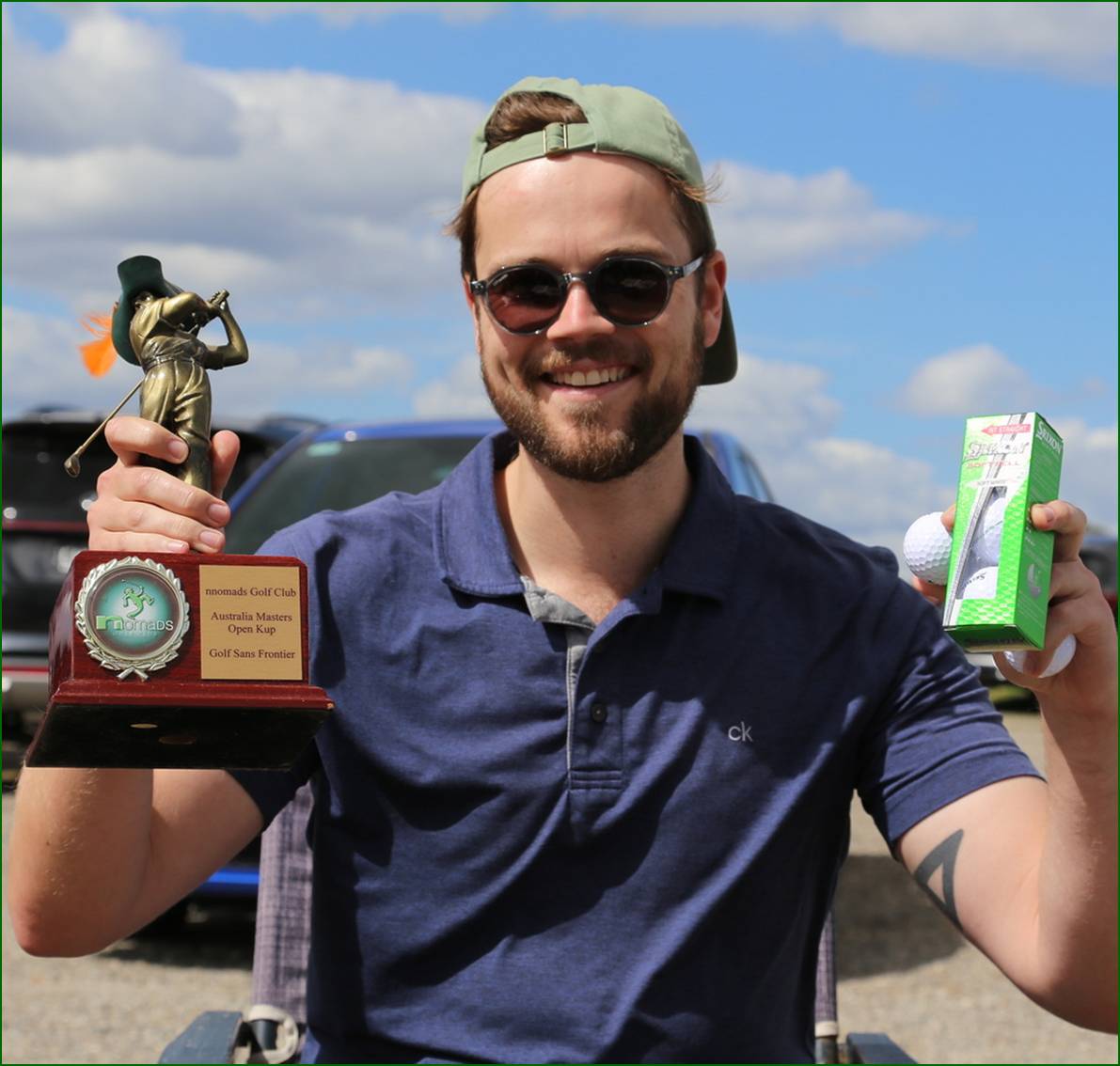 A person holding up two trophies

Description automatically generated